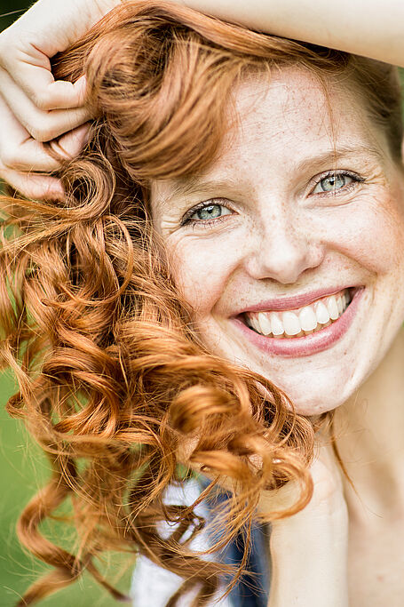 A woman with red hair smiling brightly